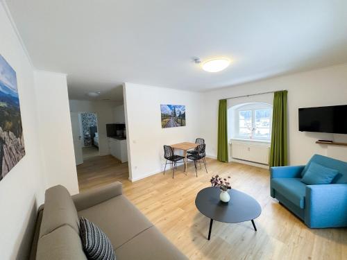 ein Wohnzimmer mit einem Sofa und einem Tisch in der Unterkunft Holly GmbH Ferienwohnungen in Bad Alexandersbad