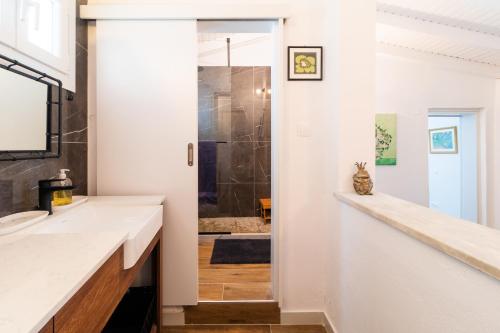 W łazience znajduje się umywalka i prysznic. w obiekcie Villa Luminosa by Corfuescapes w mieście Spartýlas