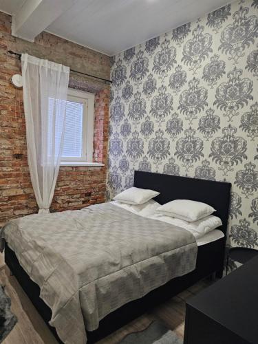 a bedroom with a bed and a brick wall at Apartment Valgeranna in Audru