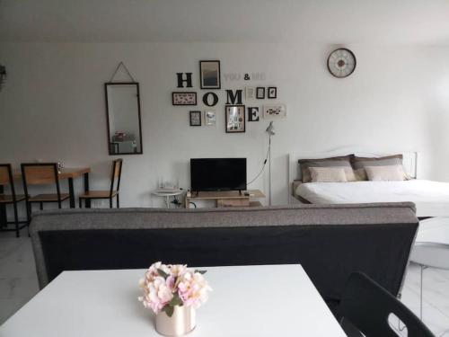 a living room with two beds and a table with flowers at Cozy roomy condo near Big C and Payap University in Chiang Mai