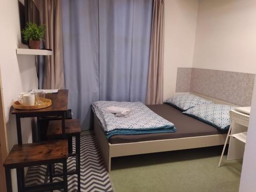 um pequeno quarto com uma cama e uma mesa em Vila Callum RELAX & WELLNESS em Ostrava