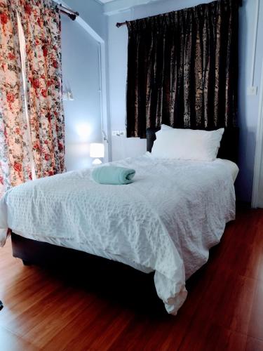 a bedroom with a bed with a blue pillow on it at Mango Tree Guestroom in Bangkok