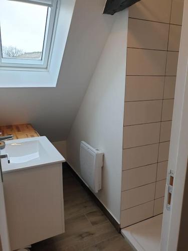 une petite salle de bain avec un lavabo et une fenêtre dans l'établissement Gîte des bords du Lot, à Saint-Côme-dʼOlt