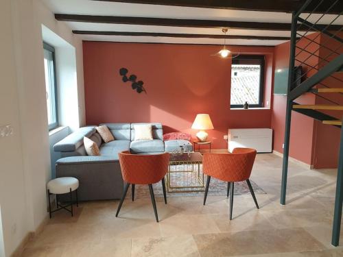 un salon avec un canapé, une table et des chaises dans l'établissement Gîte des bords du Lot, à Saint-Côme-dʼOlt