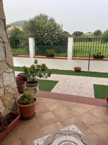 a patio with potted plants and a fence at Janas B&B in Posada