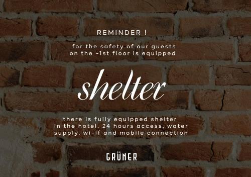 a brick wall with the words shelter on it at Gruner Hotel in Lviv