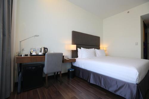 a hotel room with a bed and a desk at WP Hotel in Kuala Lumpur