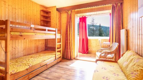 une chambre avec deux lits superposés et une fenêtre dans l'établissement Hippocampe 20 - Appt cosy 4-6 pers, à Chamrousse