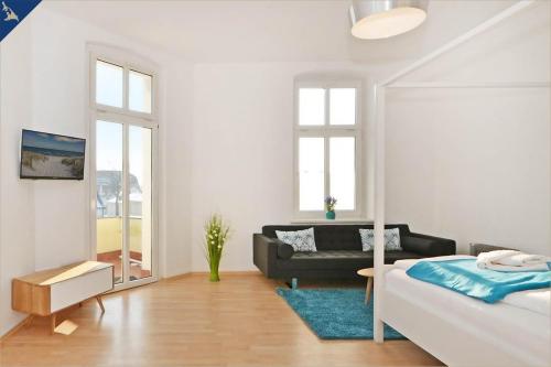 a white living room with a bed and a couch at Apartment Karlskrona in Ahlbeck