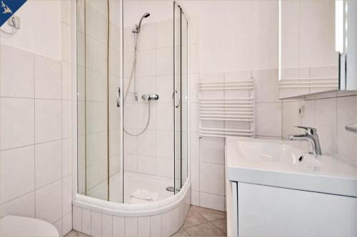 a white bathroom with a shower and a sink at Apartment Karlskrona in Ahlbeck