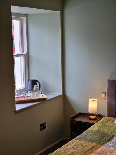 a bedroom with a mirror and a table with a lamp at Harlech House in Harlech