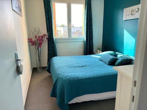 ein blaues Schlafzimmer mit einem Bett und einem Fenster in der Unterkunft Bougainvillers YourHostHelper in Saint-Cyr-sur-Mer