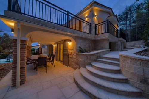 a patio with stairs leading up to a house at Villa Sea Queen in Šilo