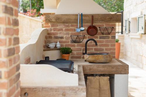 シロにあるVilla Sea Queenのシンクとレンガの壁のあるキッチン
