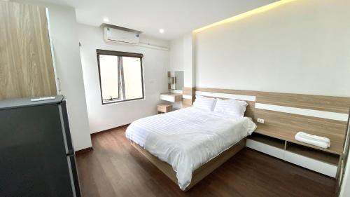 a bedroom with a white bed and a window at Era Apartment Ham Long in Hanoi