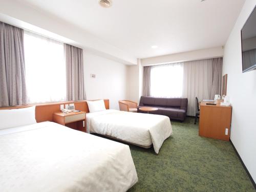 a hotel room with two beds and a couch at SAIDAIJI GRAND HOTEL - Vacation STAY 92828 in Okayama