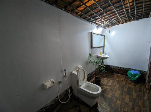 a bathroom with a toilet and a sink at Tides by TB in Canacona