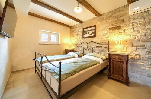 シロにあるVilla Sea Queenのベッドと石の壁のある寝室