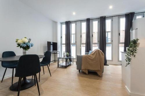 a living room with a table and chairs and windows at La La Suites Rianal in Jerez de la Frontera