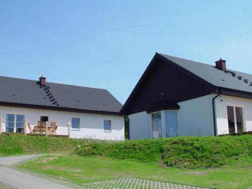 zwei weiße Häuser mit schwarzem Dach in der Unterkunft Cottage Heringsdorf in Bansin