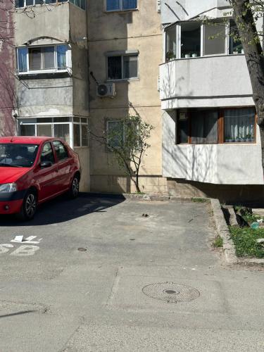 a red car parked in front of a building at Apartament Sorin in Tulcea