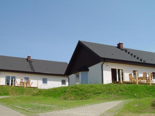 zwei weiße Gebäude mit schwarzem Dach in der Unterkunft Cottage Heringsdorf in Bansin