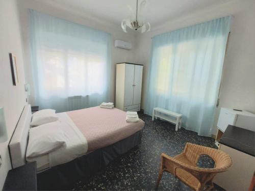 een slaapkamer met een bed, een stoel en een raam bij Villa Silvia b&b in Marina di Camerota