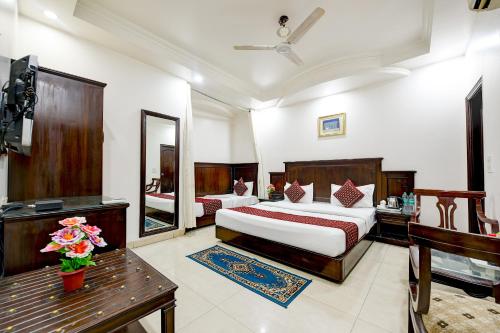 a hotel room with two beds and a mirror at Hotel Legend - Walk-In from New Delhi Railway Station in New Delhi