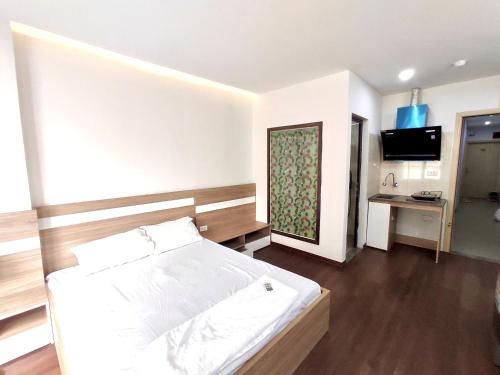 a bedroom with a bed and a television in it at Era Apartment Ham Long in Hanoi