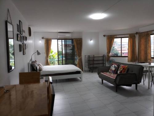 ein Wohnzimmer mit einem Bett und einem Sofa in der Unterkunft Cozy roomy condo near Big C and Payap University in Chiang Mai