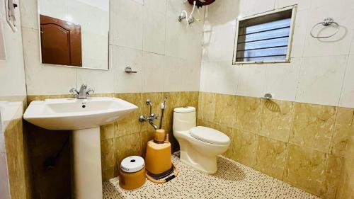 ein Bad mit einem Waschbecken und einem WC in der Unterkunft Red Stone Villas in Madikeri