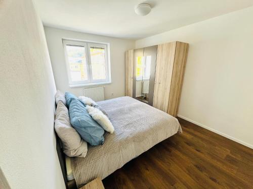 ein Schlafzimmer mit einem Bett mit blauen Kissen darauf in der Unterkunft H5 apartman 2 bedrooms with balcony and free parking in Žilina