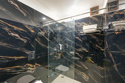 a bathroom with a black and gold marble wall at Hotel Legend - Walk-In from New Delhi Railway Station in New Delhi