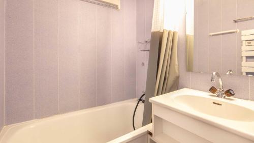 une salle de bain avec un lavabo et une baignoire et un lavabo dans l'établissement Les Marmottes -311- appt lumineux 4-6 pers, à Chamrousse
