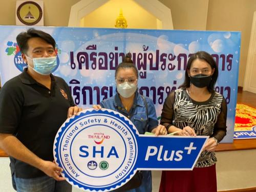 a group of three people wearing masks holding a sign at Noot's Guesthouse in Kanchanaburi
