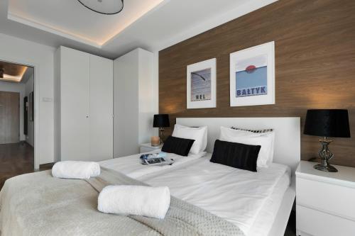 ein Schlafzimmer mit einem großen Bett mit weißer Bettwäsche in der Unterkunft Elite Apartments Albatros in Danzig
