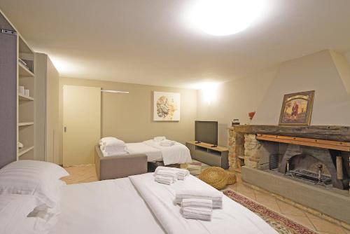 a living room with two beds and a fireplace at Villa Riai in Moniga