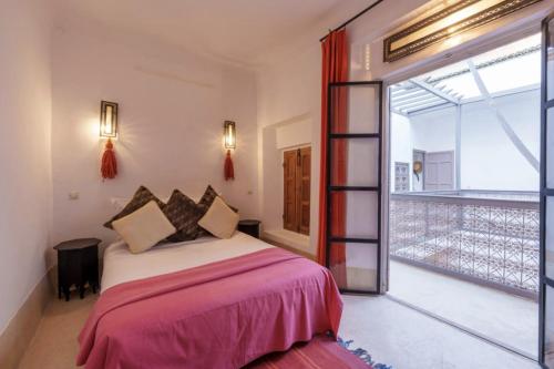 um quarto com uma cama e uma grande janela em Riad Slima en exclusivité petits déjeuners compris em Marrakech