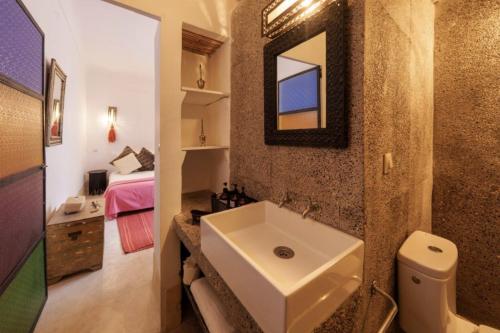 a bathroom with a sink and a mirror and a bed at Riad Slima en exclusivité petits déjeuners compris in Marrakesh