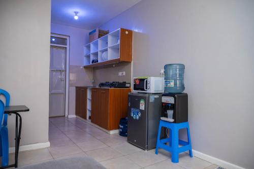 een kleine keuken met een koelkast en een kruk bij Hassan Furnished Superior Studio, Nairobi in Nairobi
