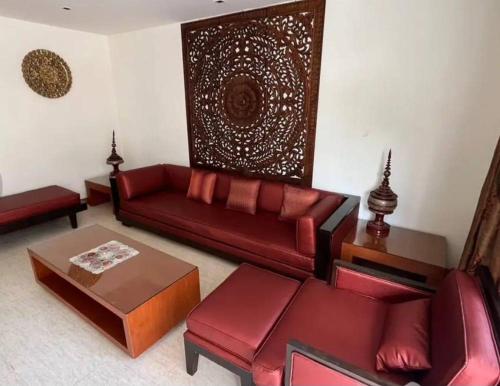 a living room with a red couch and a table at Hua Hin Blue Lagoon in Cha Am