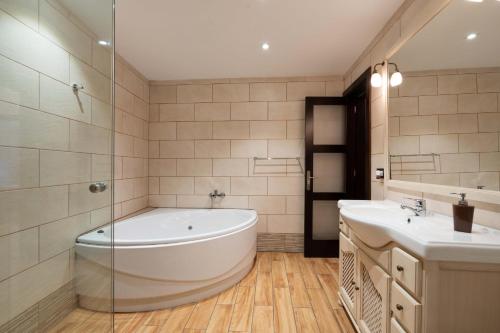 een grote badkamer met een bad en 2 wastafels bij Las Fajanas de Gáldar in Las Palmas de Gran Canaria