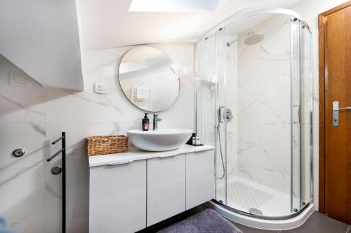 a white bathroom with a sink and a shower at Apartment Lili in Poreč