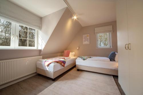 dwa łóżka w pokoju z dwoma oknami w obiekcie Gut Oehe w mieście Maasholm