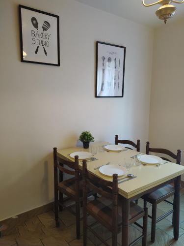 a dining room table with chairs and a table and a picture at Gîte l' Odyssée in Espalion