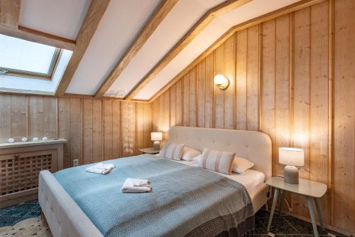 1 dormitorio con 1 cama en una habitación con paredes de madera en Ferienwohnung Panoramablick - Alpenmagie Suites en Oberaudorf
