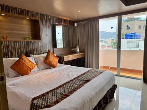 a bedroom with a bed with a desk and a window at Condo Minium Patong Phuket in Patong Beach