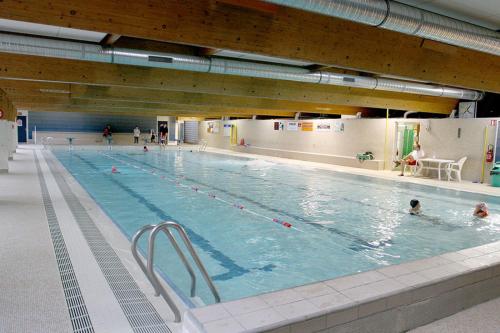une grande piscine avec des gens dans l'eau dans l'établissement Petit nid douillet dans un cocon de verdure, à Vaires-sur-Marne