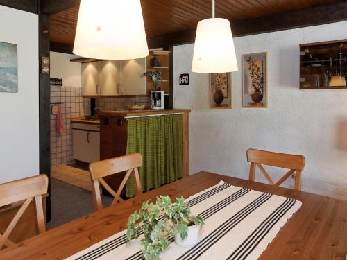 uma cozinha e sala de jantar com mesa e cadeiras em Wooden chalet with terrace near a swimming lake em Waldkirchen