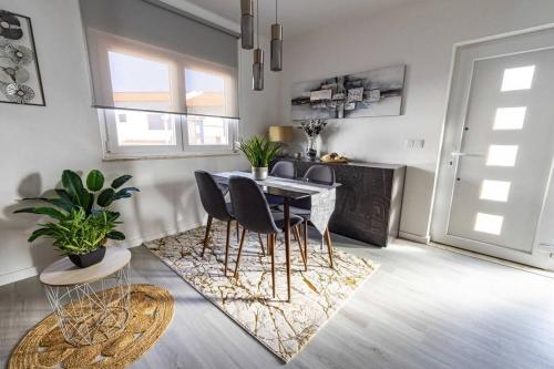 a dining room with a table and chairs at Brisa Mar/Villa Eira Nova in Porto Covo
